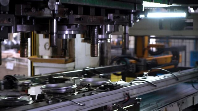 Close up view of a large hydraulic transfer press line shaping metal parts in a factory.