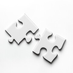 Fototapeta premium Two white puzzle pieces lying on a clean surface ready to be connected together for a creative project