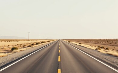 A scenic road winds through a dramatic desert landscape, with towering red rock cliffs and a clear blue sky in the background.