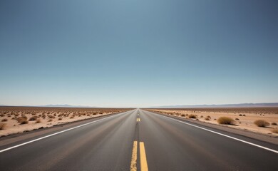 A scenic road winds through a dramatic desert landscape, with towering red rock cliffs and a clear blue sky in the background.