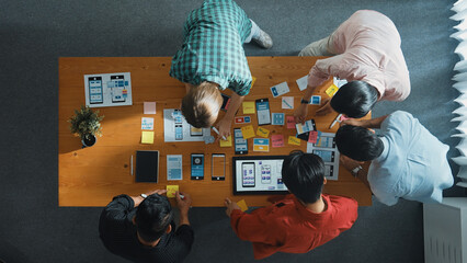 Top down view of business team writing idea on sticky note while planing for Ux Ui design for...