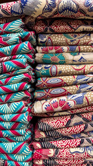 Vibrant Stacks of Indonesian Batik Fabrics: A Colorful Textile Display in a Market