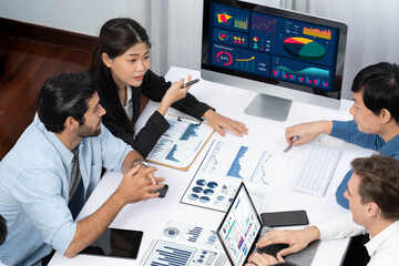 Analyst team utilizing BI Fintech to analyze financial data at table in meeting room. Businesspeople analyzing BI dashboard power on paper for business insight and strategic marketing planning.Prudent