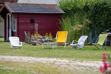 Ensemble de différentes chaises de détente, installée sur l'herbe dans jardin. Bassin d'au avec...