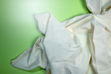 Top view of crumpled white fabric on a colored background