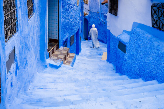 Man in traditional white robe in the street of the blue city, Chefchaouen, Morocco