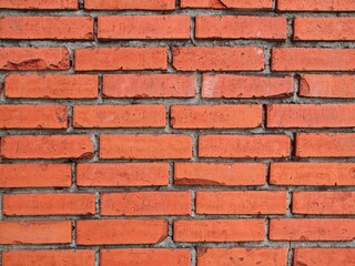 Obraz premium Tidy brick wall with slightly damaged bricks