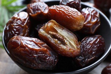 Tasty dried dates in bowl on table, closeup
