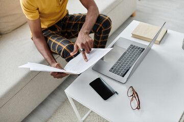 Young African American man balancing work and adventure as a digital nomad in a cozy environment