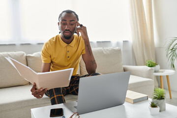Focused young man engrossed in work while sitting comfortably at home