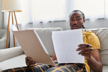 Young man engaged in remote work at home, enjoying the freedom of digital nomad life