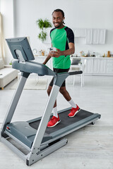 Fototapeta premium Young african american man enjoying a workout at home while staying connected and active