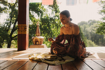 Woman practicing yoga and meditation in a Buddhist temple, relaxed with closed eyes. Mindful...