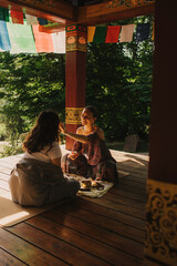 Close up of female mentor and student before Mindful meditation and yoga in the gazebo....