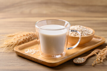 Oat milk in cup glass on wooden background, Alternative milk made from plant, non dairy