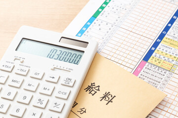 机に置かれた確定申告書類と電卓と給料袋