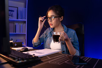 Creating young beautiful Asian creative woman thinking of sales target report on business market graph folder paperwork report, looking out of indoor with holding pen at neon at night time. Stratagem.