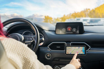 A female driver using a phone navigator in the car,