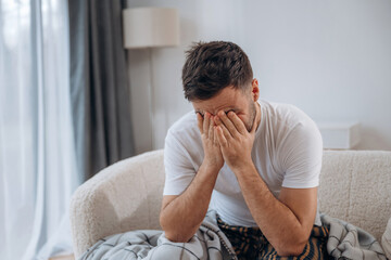 Terrible headache. Sick man is feeling bad at home