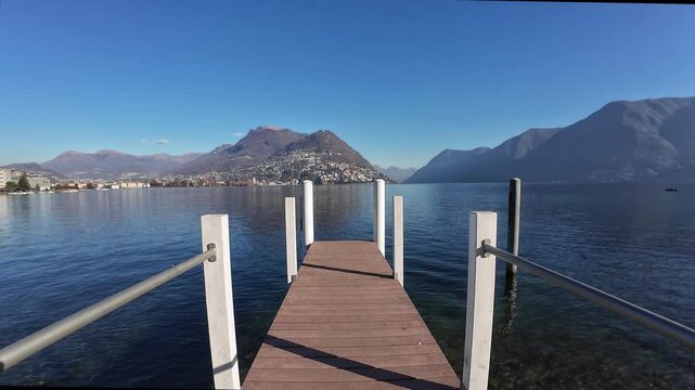 Jetty in Lugano Paradiso, Switzerland along Ceresio lake. Bre Mount in the background