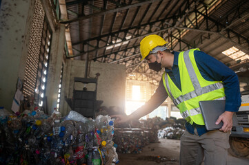 A diligent worker in a safety vest and mask meticulously inspects a pile of plastic bottles within...