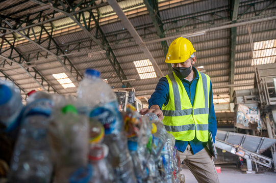 Recycling Plant Worker Inspecting Plastic Bottles 
