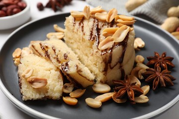 Delicious sweet semolina halva with peanuts and spices on white table, closeup