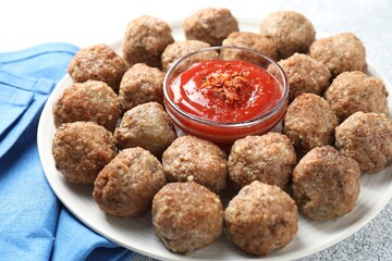 Delicious meatballs with ketchup and spices on light textured table, closeup