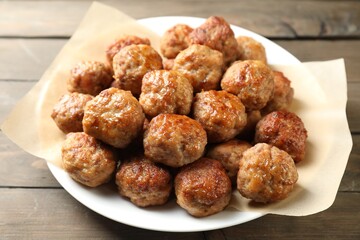 Many delicious meatballs on wooden table, closeup