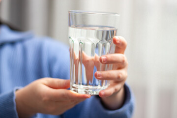 Close up image of woman holding glass of water. Concept of healthy lifestyle, beauty skin health care treatment