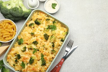 Tasty pasta casserole with cheese and broccoli served on grey table, flat lay. Space for text