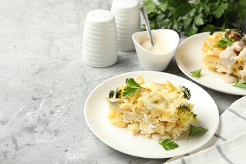 Tasty pasta casserole with cheese and broccoli served on grey table, closeup. Space for text