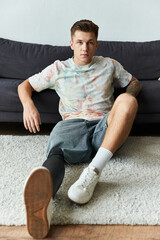 Young man confidently showcasing his stylish prosthetic leg while relaxing indoors