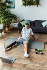 Young man with prosthetic leg enjoying a workout session at home in a stylish living room
