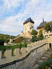 Fototapeta premium A different perspective. Sunny autumn day. A view of the medieval castle Karlstejn and steps. The walls and forests around. Sunny day.