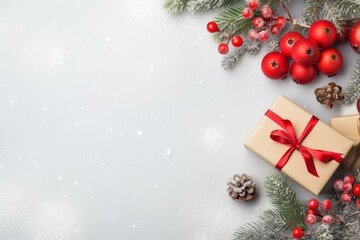 Christmas composition with gift box, fir branches, red baubles and pine cones on grey background