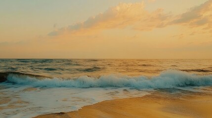 Fototapeta premium A serene ocean view with small waves and golden sand under a pastel-colored sky, creating a tranquil mood