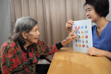 Asian Elderly Woman with Dementia Practicing match pictures.