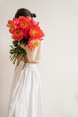 Woman Holding Bright Flowers in White Dress