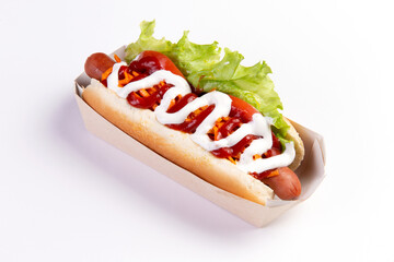 Appetizing hot dog in packaging on a light background.