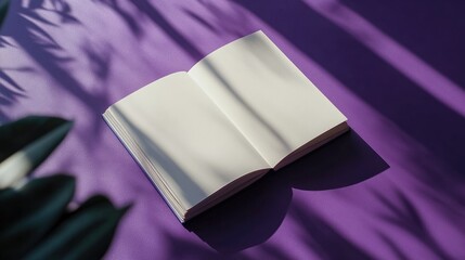 Top view of a plain sketchbook surrounded by soft shadows on a striking purple background with copy space