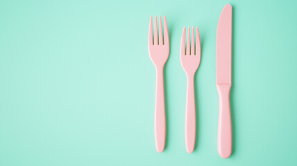 Three pink plastic utensils on a green background