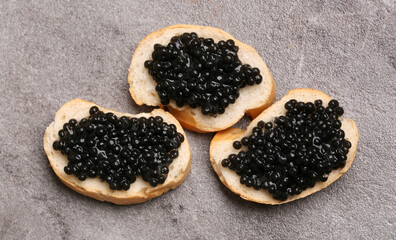 bread with black caviar and a light background