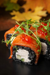Delicious fresh sushi roll with cucumber, salmon and dark rice