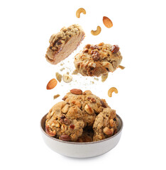 Yummy nut cookies falling into bowl on white background