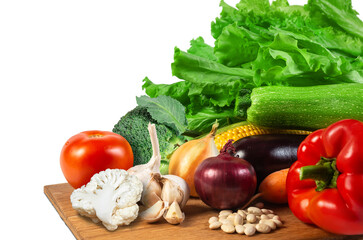 Fresh assorted vegetables arranged on a wooden surface ready for cooking or salad preparation