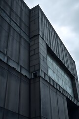 Fototapeta premium A modern, industrial building with a metallic facade under a cloudy sky.