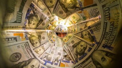 Wide-Angle Perspective Inside a Jar of Hundred-Dollar Bills as a Man Observes Through the Opening With a Serious Expression, Surrounded by Currency. Focus on Financial Observation.