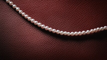 A white pearl necklace artistically curved on a rich reddish-brown leather surface with plenty of copy space for branding.