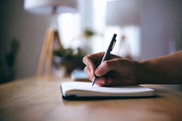 Hand of a person writing in a notebook.